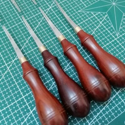 Leather edge bevelers arranged on cutting mat