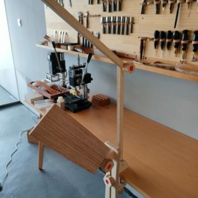 Wooden stitching pony holding leather for hand stitching