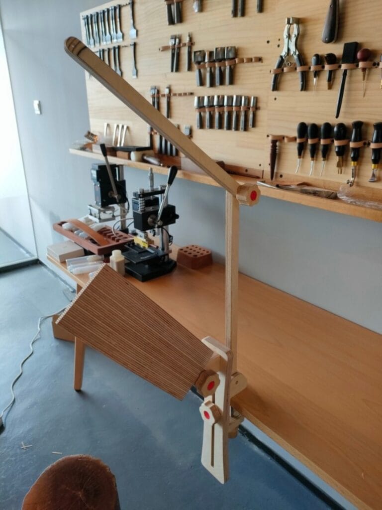 Wooden stitching pony holding leather for hand stitching