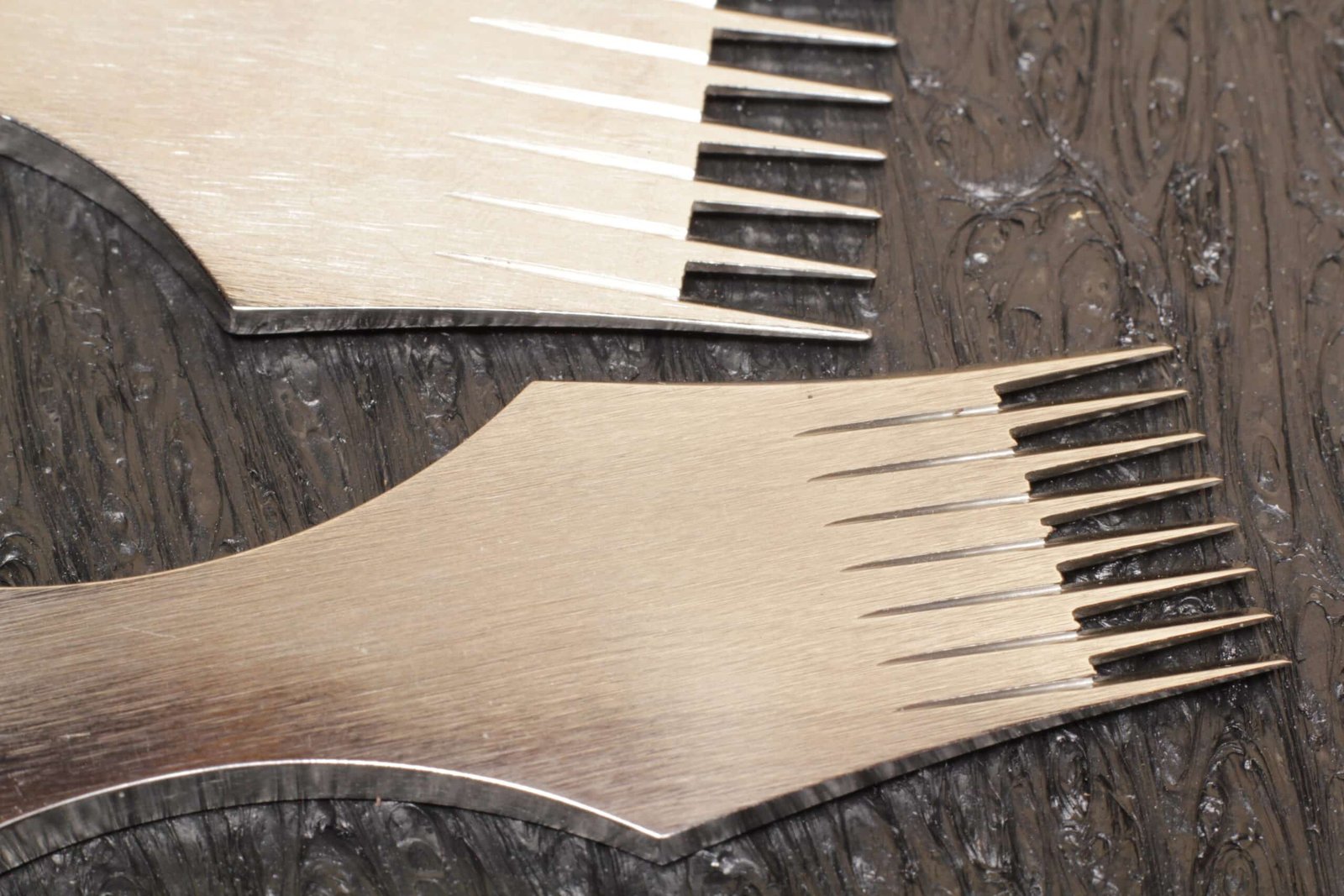 Two pricking irons on an Oka cutting board showing tine spacing comparison