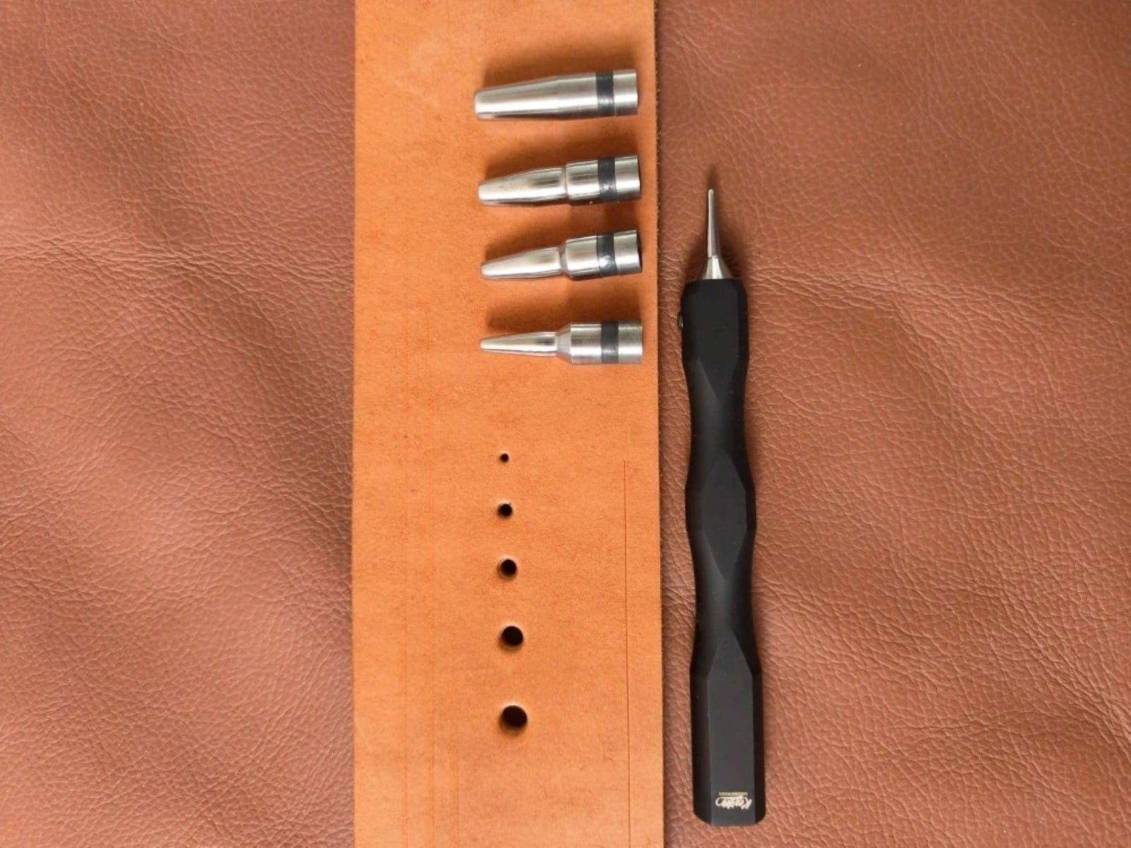 Kevin Lee 1–5mm interchangeable-tip hole punch set with handle, five tips and sample holes in leather