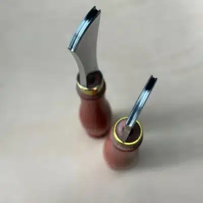 AIGAEER Red-Handle Creasers – Working Edges Top-down view of two AIGAEER red-handle creasers showing the grooved working edges of both heads