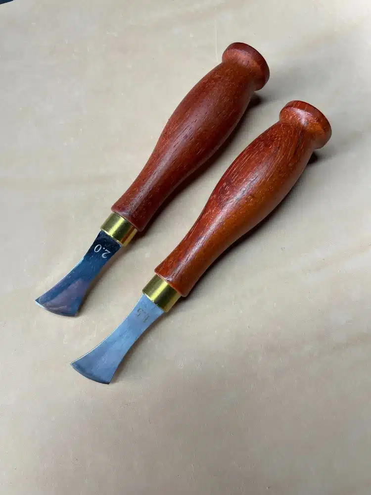 Two AIGAEER creasers with red handles and brass-coloured collars, heads marked 1.5 and 2.0
