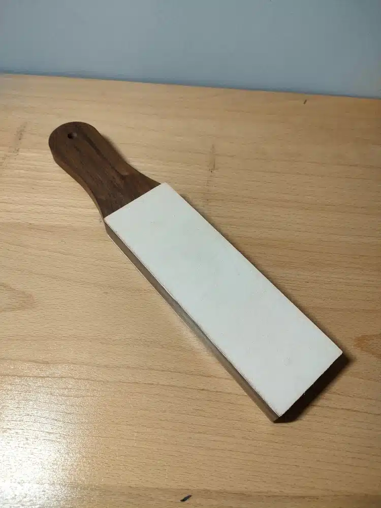 Kevin Lee black walnut strop photographed from the handle end, showing the white stropping surface