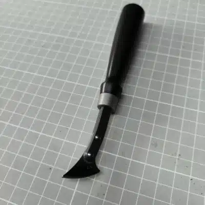 Kevin Lee G10-handle fixed creaser with a black handle, silver-coloured collar and riveted head marked 1.5, on a cutting mat
